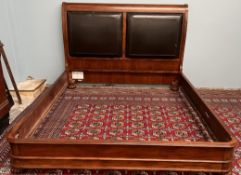 A modern sleigh bed with twin leather pads,