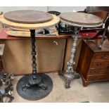 A pair of cast iron pub tables with sea creature and turned columns on scrolling feet with turned