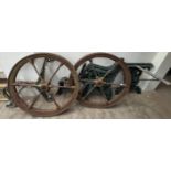 A pair of cast iron wheels together with three cast iron bench seat ends and cast iron table ends