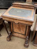 A Victorian walnut Davenport with a raised stationery compartment above a sloping fall enclosing