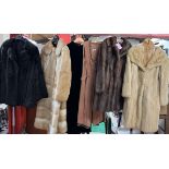 Four fur coats together with a jacket and a dress