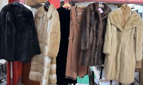 Four fur coats together with a jacket and a dress