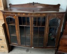 A 20th century mahogany display cabinet with a raised back, and four glazed doors and sides,
