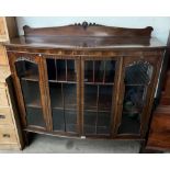 A 20th century mahogany display cabinet with a raised back, and four glazed doors and sides,