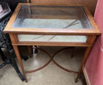 An Edwardian mahogany inlaid bijouterie table with a rectangular glazed top and sides on square