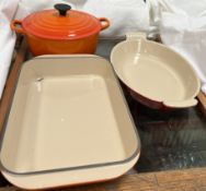 A Le Crueset casserole dish and cover together with two Le Crueset open dishes