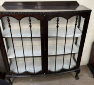 A 20th century mahogany display cabinet with a pair of glazed doors with glazing bars and glazed