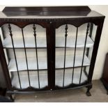 A 20th century mahogany display cabinet with a pair of glazed doors with glazing bars and glazed