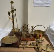 A brass balance beam scales together with brass candlesticks, brass letter scales, brass sundial,