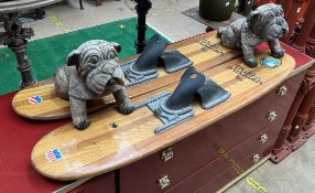 A pair of Trik Master water skis together with a pair of carved bulldogs