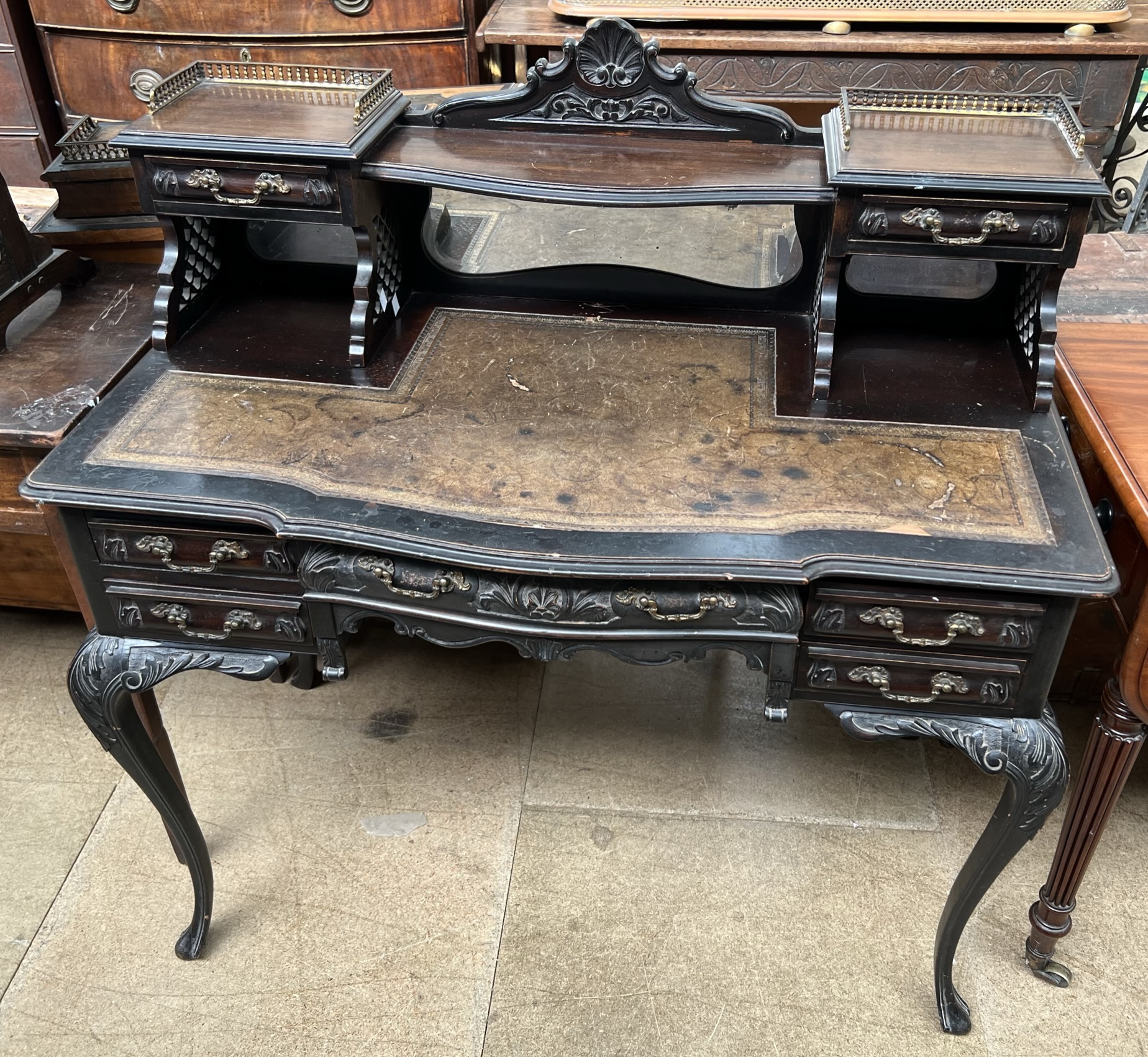 An Edwardian ebonised ladies writing table with a raised superstructure above a leather inset top