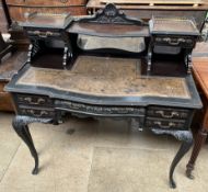 An Edwardian ebonised ladies writing table with a raised superstructure above a leather inset top