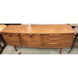 A mid 20th century G-plan teak sideboard with a rectangular top above two cupboards and three