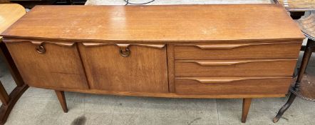 A mid 20th century G-plan teak sideboard with a rectangular top above two cupboards and three