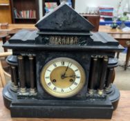 A black slate mantle clock of architectural form,