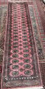 A Pakistani Bokhara wool pile rug with a pink ground and multiple guard stripes,