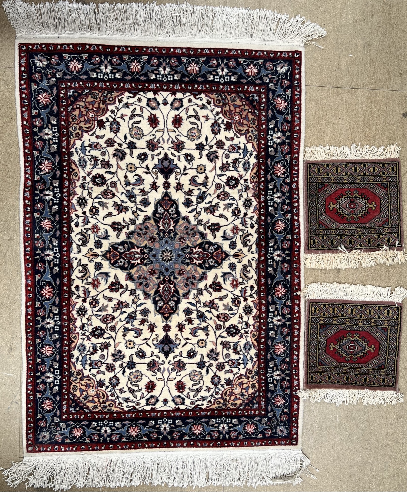 A Chinese 200 line wool pile cream ground rug with floral centre,
