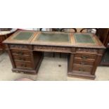 An Edwardian oak Maple and Company desk with three leather inset hinged writing surfaces above a