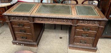 An Edwardian oak Maple and Company desk with three leather inset hinged writing surfaces above a