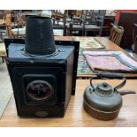 A Linley & Co lamp with a red bulls eye lens and a large square lens to the reverse with a chimney