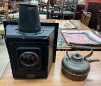A Linley & Co lamp with a red bulls eye lens and a large square lens to the reverse with a chimney