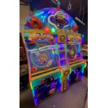 A UDC Meteor Ball arcade machine, with lit score display, prize compartments, and coin slots,