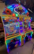 A UDC Meteor Ball arcade machine, with lit score display, prize compartments, and coin slots,