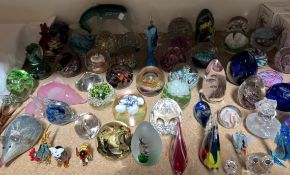 A collection of Caithness and other glass paperweights together with glass animals,