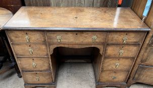 A 20th century walnut dressing table / desk with a crossbanded top above a central kneehole and