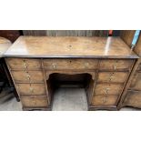 A 20th century walnut dressing table / desk with a crossbanded top above a central kneehole and