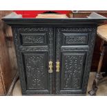 A 19th century carved ebonised bookcase top with a pair of carved doors