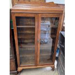 A 20th century oak display cabinet with a caddy top and a pair of glazed doors on cabriole legs and