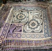 An embroidered bedspread decorated with flowers,