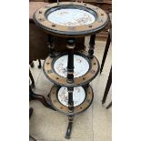 A late Victorian three tier cake stand inset with pottery dishes on shaped legs