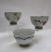 Three assorted stoneware footed bowls in the Chawan style, decorated with flowers and lines,