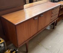 A G-plan teak sideboard, of rectangular form with two cupboards and four drawers on tapering legs,