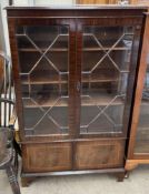 An early 20th century mahogany bookcase with a pair of glazed and cupboard doors on bracket feet