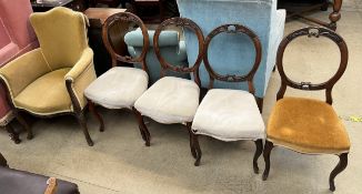 A Victorian walnut elbow chair together with a set of four Victorian balloon back dining chairs