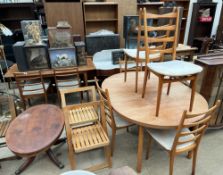 A mid 20th century teak extending dining table and six chairs together with a pair of folding