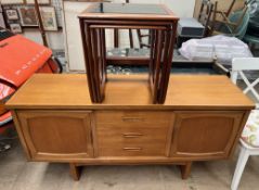 A mid 20th century teak sideboard with a set of three drawers flanked by a pair of cupboards,
