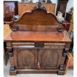 A Victorian mahogany chiffonier with a shaped back above two frieze drawers and two cupboards on a