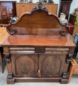 A Victorian mahogany chiffonier with a shaped back above two frieze drawers and two cupboards on a