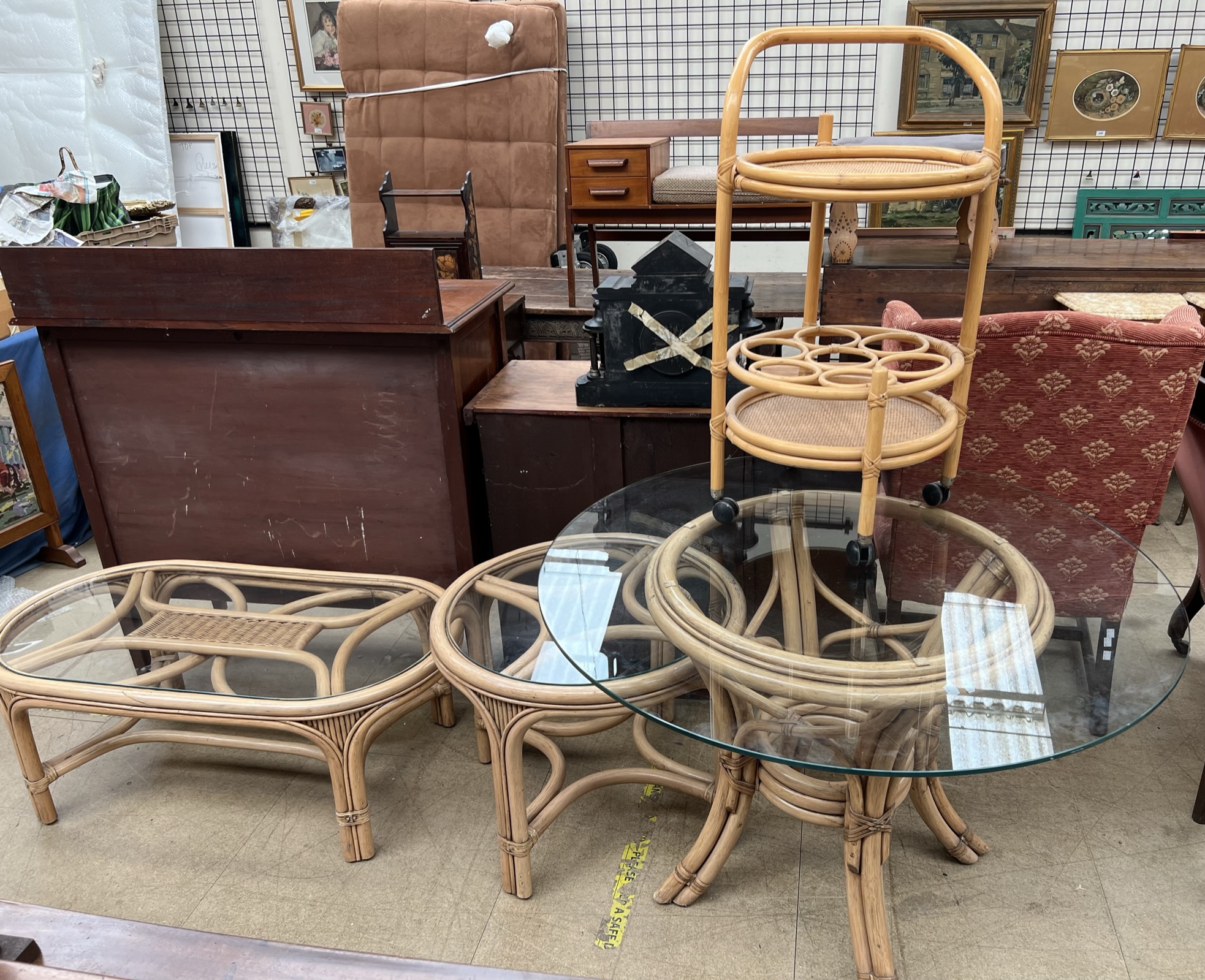 A bamboo and circular glass dining table together with two bamboo coffee tables and a bamboo drinks