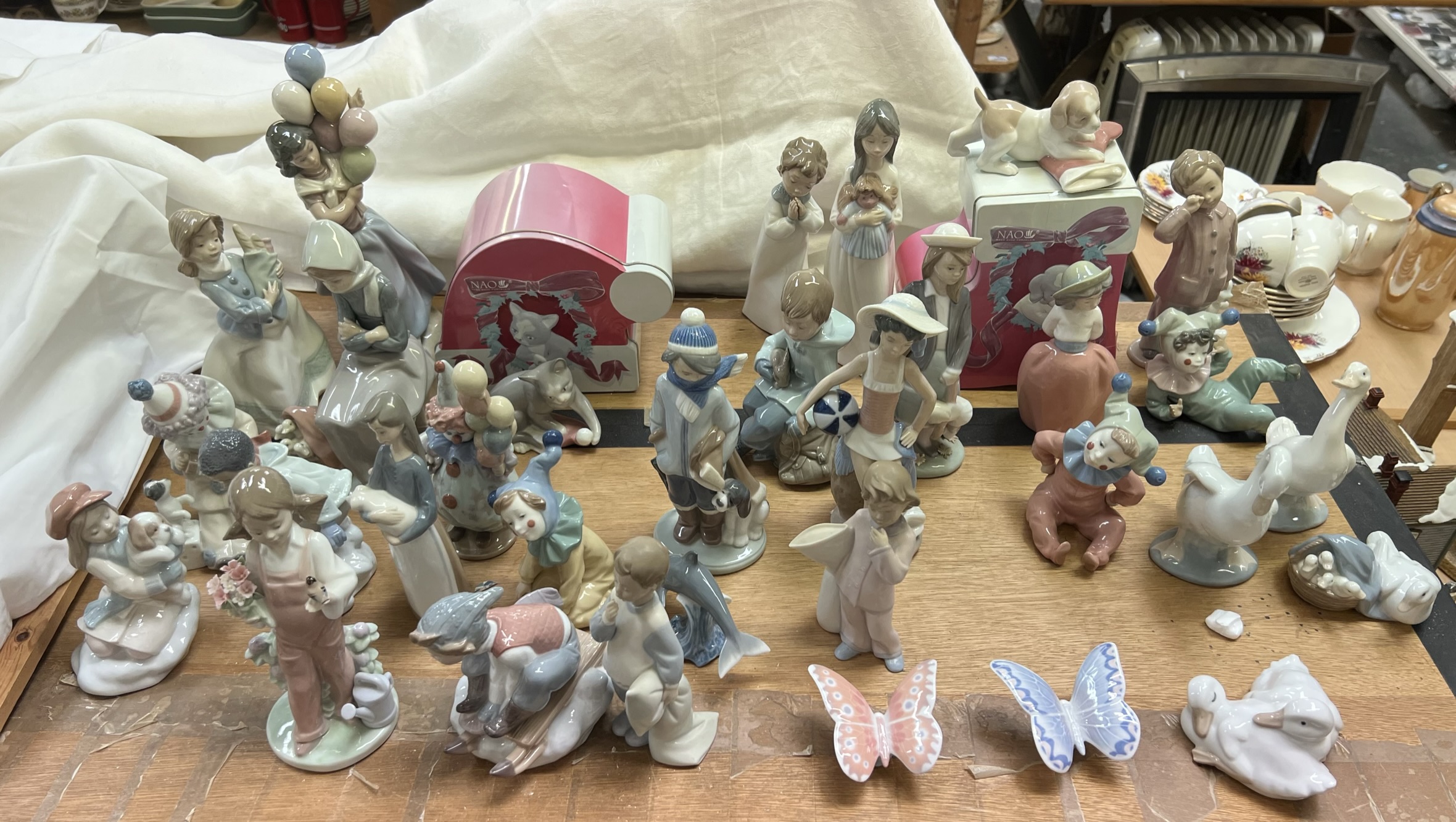 A collection of Lladro and Nao porcelain figures including a balloon girl, clown, children,