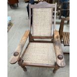 A Chinese hardwood steamer chair with a sloping back and basket weave back and seat