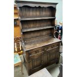 A 20th century oak dresser with a moulded cornice above two shelves,