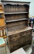 A 20th century oak dresser with a moulded cornice above two shelves,