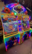 A UDC Meteor Ball arcade machine, with lit score display, prize compartments, and coin slots,