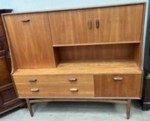 A G-plan teak wall unit, the upper section with drop down drinks compartments and double cupboard,