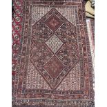 A red ground rug with a central medallion comprising smaller medallions and multiple guard stripes,